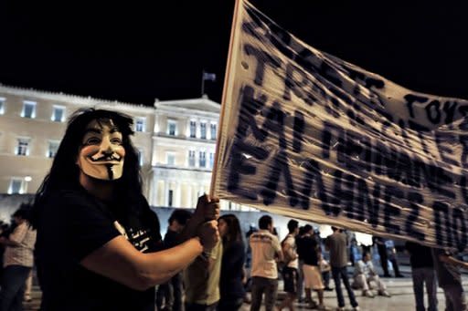 A demonstrator wears a mask while protesting in front of the Greek parliament against new austerity measures, on September 25. Europe's failure to tackle crippling Greek debt is "scaring the world," US President Barack Obama warned as Germany stoked fears Tuesday of a worldwide plunge back into recession