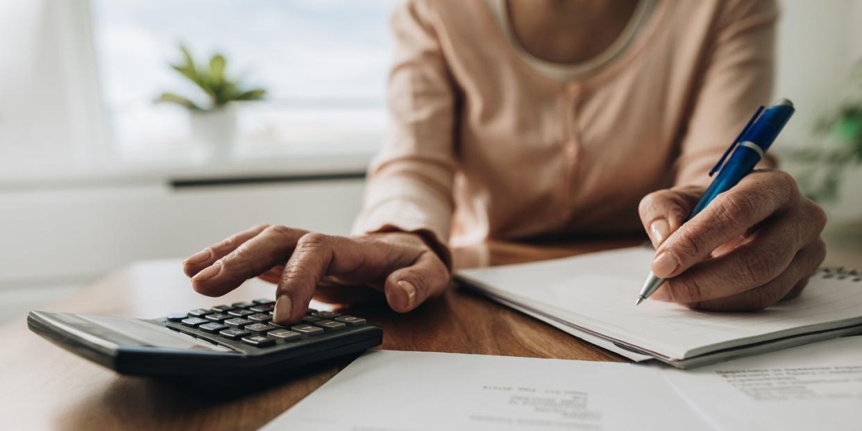 person using calculator to calculate on a car loan