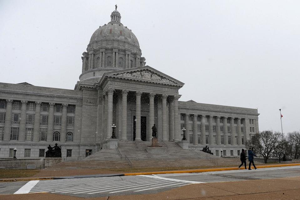 PHOTO: Pedestrians walk along as snow flurries fall outside the Missouri State Capitol Building on January 17, 2021 in Jefferson City, Missouri. (Michael B. Thomas/Getty Images)