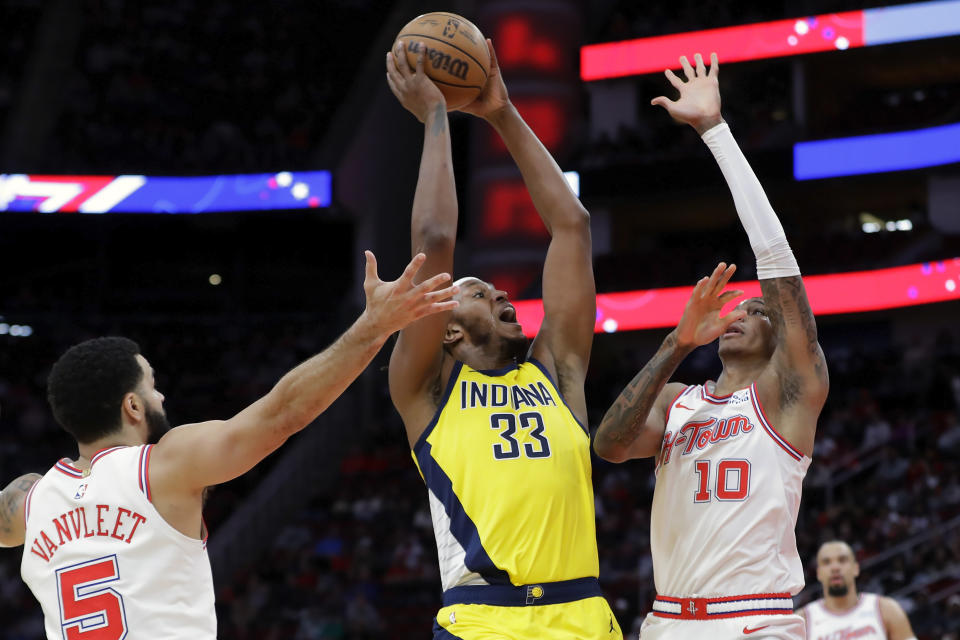 Indiana Pacers center Myles Turner (33) shoots from between Houston Rockets guard Fred VanVleet (5) and forward Jabari Smith Jr. (10) during the first half of an NBA basketball game Tuesday, Dec. 26, 2023, in Houston. (AP Photo/Michael Wyke)