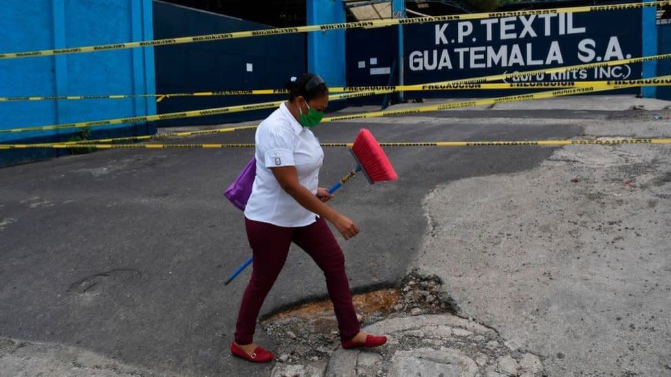 Mujer con elementos de limpieza camina en Guatemala