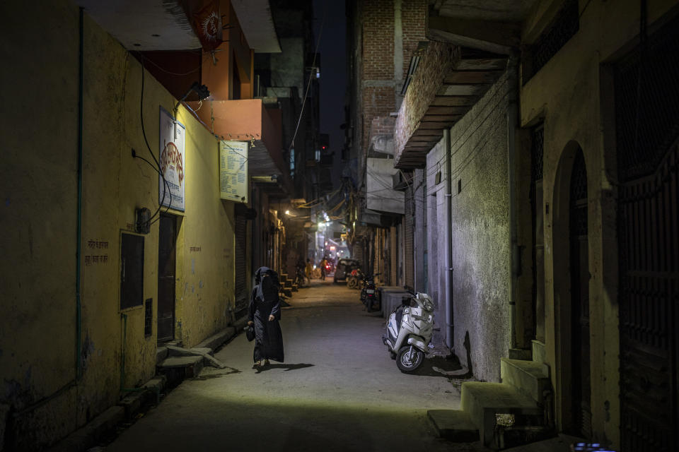 A burqa clad Muslim woman walks in an alleyway in North Ghonda neighborhood, one of the worst riot affected area during the February 2020 communal riots, in New Delhi, India, Friday, Feb. 19, 2021. As the first anniversary of bloody communal riots that convulsed the Indian capital approaches, Muslim victims are still shaken and struggling to make sense of their struggle to seek justice. (AP Photo/Altaf Qadri)