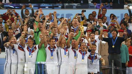 Germany's players lift the World Cup trophy as they celebrate their 2014 World Cup final win against Argentina at the Maracana stadium in Rio de Janeiro July 13, 2014. REUTERS/Michael Dalder