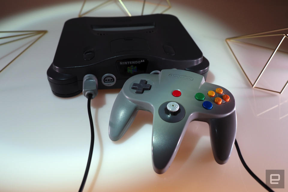 <p>Nintendo 64 on a white table with games</p>
