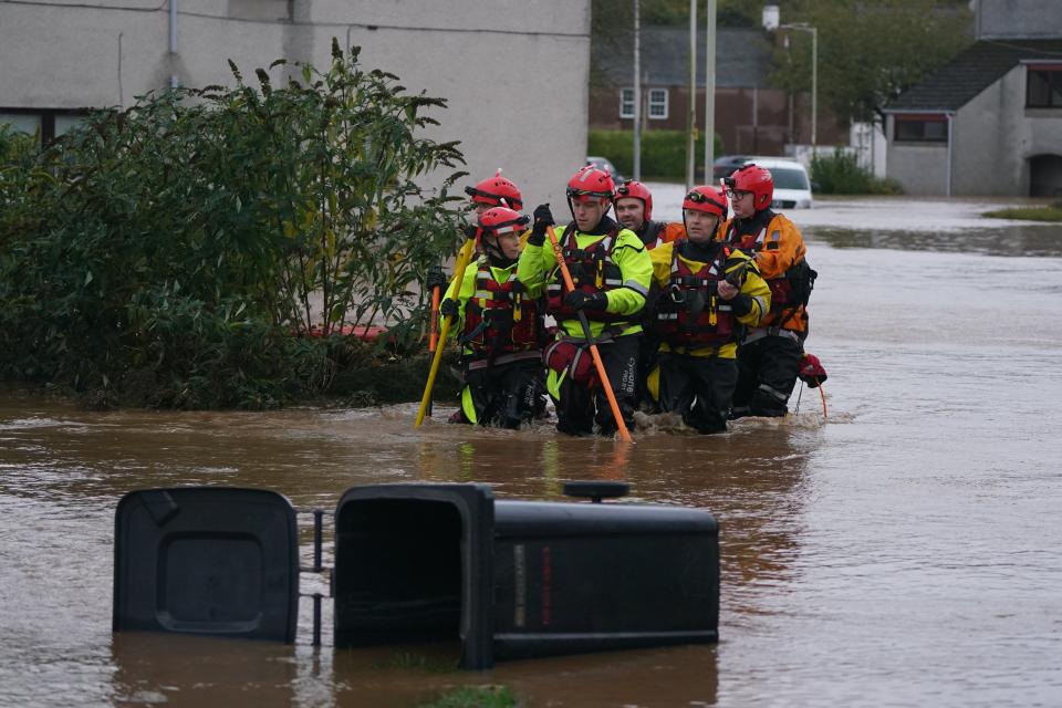 Emergency service workers walk through flood water in Brechin, Scotland (Andrew Milligan/PA Wire)