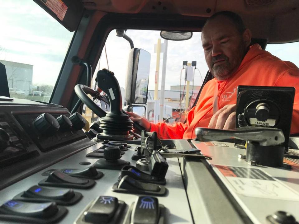 Olathe solid waste collection operator Bill Oxley operates his trash truck during a collection route on Monday, April 10, 2023.