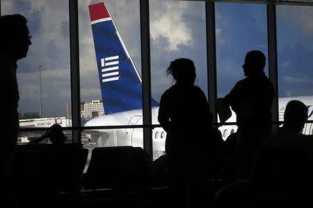 People wait for a US Airways flight to depart for North Carolina from Miami International Airport in Miami September 3, 2014. REUTERS/Carlo Allegri