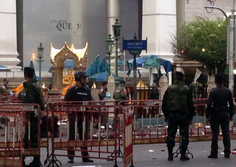 Police and soldiers stand next to the bomb damaged religious shrine in central Bangkok late on August 18, 2015