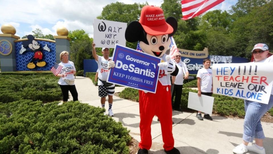 Imagen de una persona vestida del ratón Mickey con un letrero a favor de Ron DeSantis