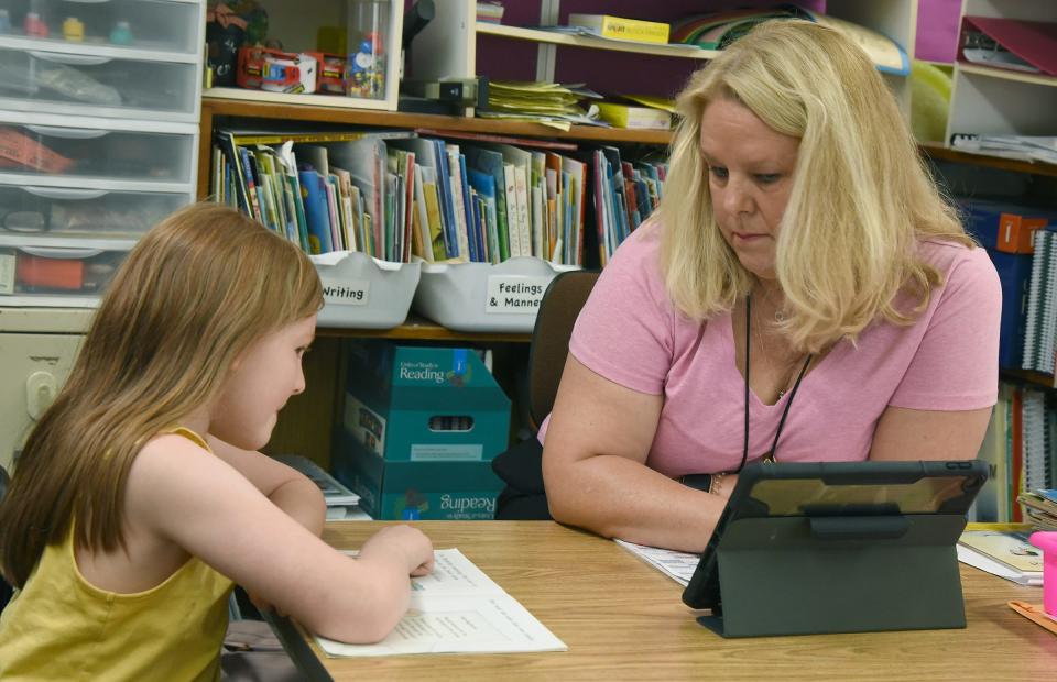 Besty Cole listens to student Kaydence Kesig as she reads for a reading test on May 23.