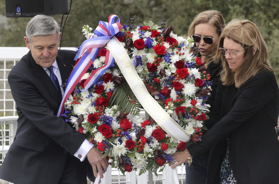 A wreath is presented by, from left, Bob Cabana, Associate Administrator of NASA; Janet Petro, NASA KSC director, and Sheryl Chaffee, daughter of Apollo 1 astronaut Roger Chaffee, during NASA's Day of Remembrance ceremony, hosted by the Astronauts Memorial Foundation at Kennedy Space Center Visitor Complex, Thursday, Jan. 26, 2023. NASA is marking the 20th anniversary of the space shuttle Columbia tragedy with somber ceremonies during its annual tribute to fallen astronauts. (Joe Burbank/Orlando Sentinel via AP)