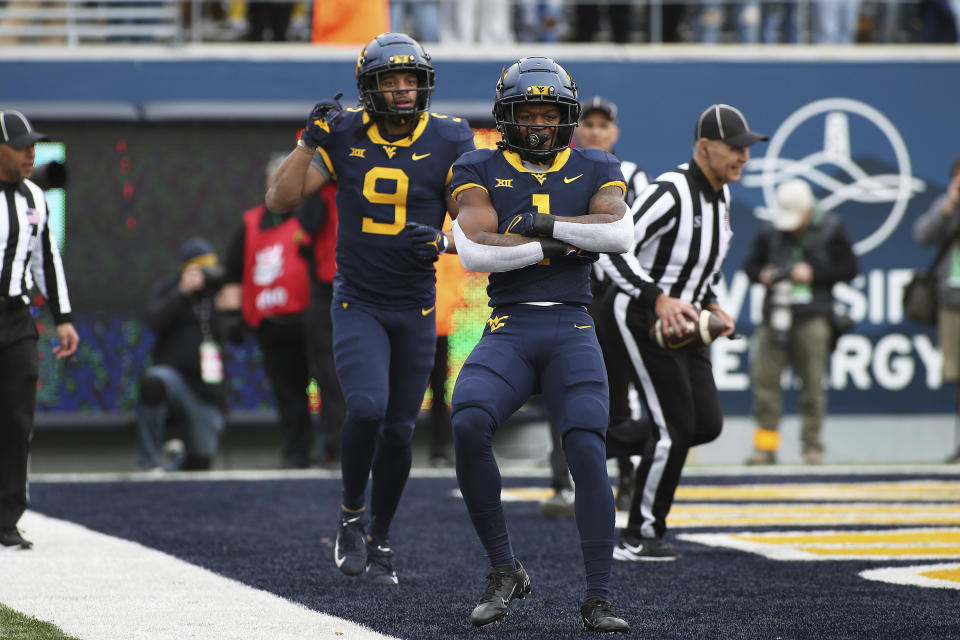 West Virginia wide receivers Isaiah Esdale (9) and Winston Wright Jr. (1) celebrate after a touchdown against Texas during the first half of an NCAA college football game in Morgantown, W.Va., Saturday, Nov. 20, 2021. (AP Photo/Kathleen Batten)