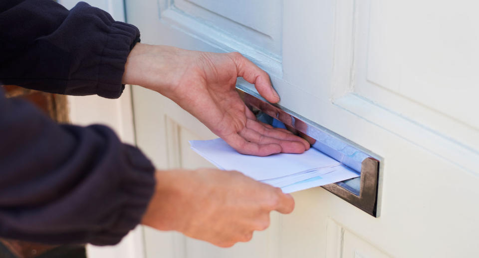 File photo of letter being slipped through a front door after a Birmingham resident received a note about his laundry.