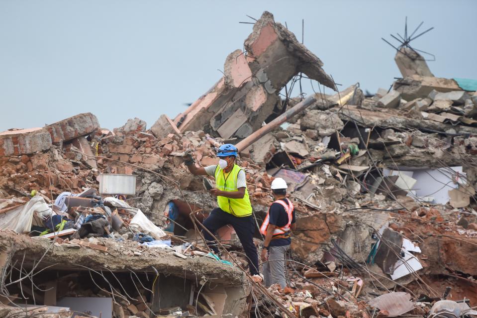 Rescue workers search for people in the rubble of a collapsed five-storey apartment building in Mahad. (Photo by PUNIT PARANJPE/AFP via Getty Images)