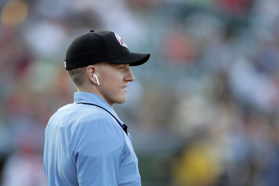 Home plate umpire Brian deBrauwere looks on while wearing an earpiece connected to a ball and strikes calling system prior to the start of the Atlantic League All-Star minor league baseball game, Wednesday, July 10, 2019, in York, Pa. deBrauwere wore the earpiece connected to an iPhone in his ball bag which relayed ball and strike calls upon receiving it from a TrackMan computer system that uses Doppler radar. The independent Atlantic League became the first American professional baseball league to let the computer call balls and strikes during the all star game. (AP Photo/Julio Cortez)