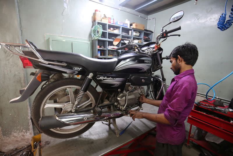 An employee works on a motorbike inside a Hero MotoCorp service station in Ahmedabad