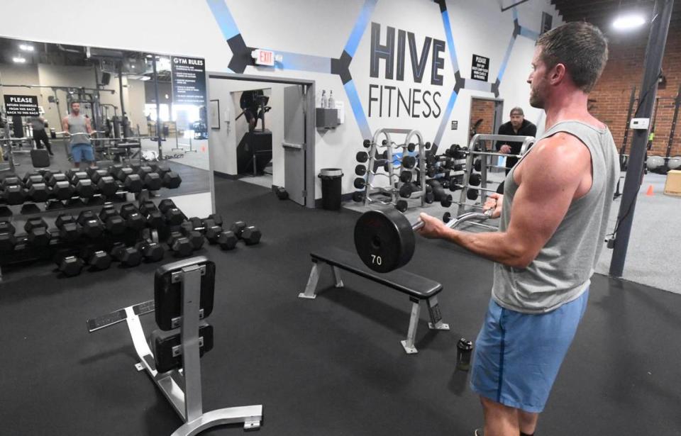 Devin Bridges curls weights while working out at Hive Fitness in Charlotte on Thursday, July 9, 2020. Gym co-owner Rob Jenkins says any new mask mandates are “utterly ridiculous” at this point.