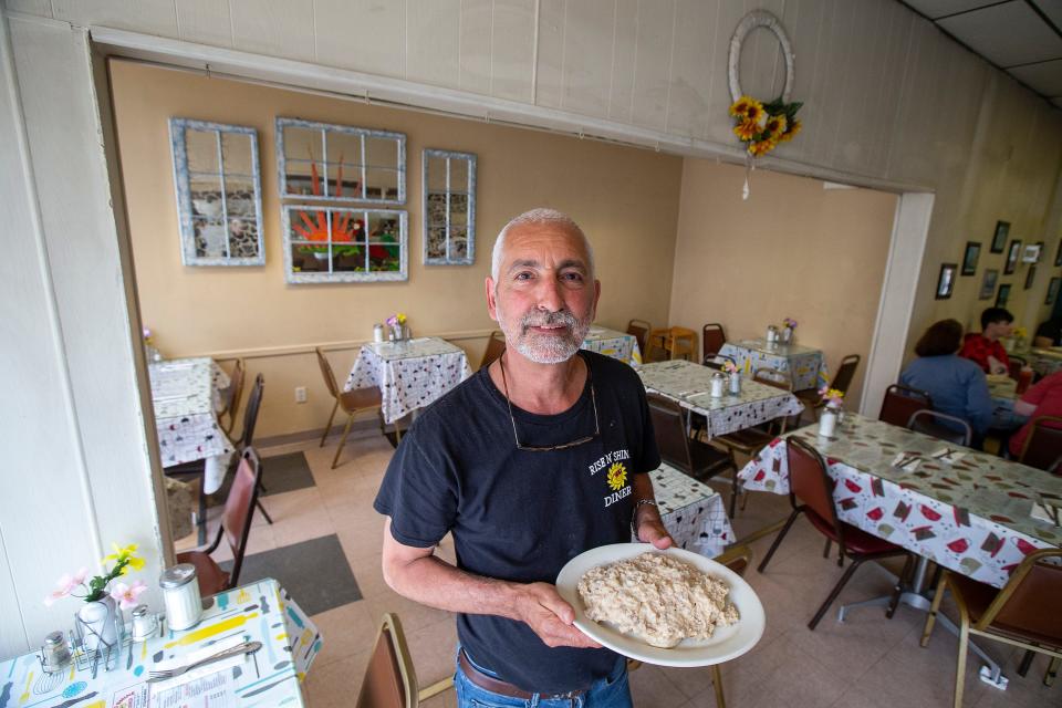 Sal Martorana, owner of Rise N Shine Diner, an Eatontown-based breakfast spot since 1987, holds a plate of his signature dish, Southern-style biscuits and sausage gravy, in Eatontown, NJ Friday, June 3, 2022.