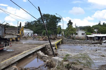 Residents stand near a ruined road after floods affected the Cordoba province February 16, 2015. REUTERS/Dario Giana