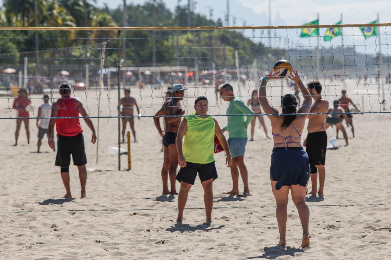 People play volleyball at Flamengo Beach amid the coronavirus pandemic on July 19, 2020, in Rio de Janeiro, Brazil. The practice of physical activities on boardwalks and individual sports at sea is allowed. However, the use of chairs and tents on the sand is still prohibited. Starting next week group sports such as volleyball and football can be practiced, but only on weekdays.