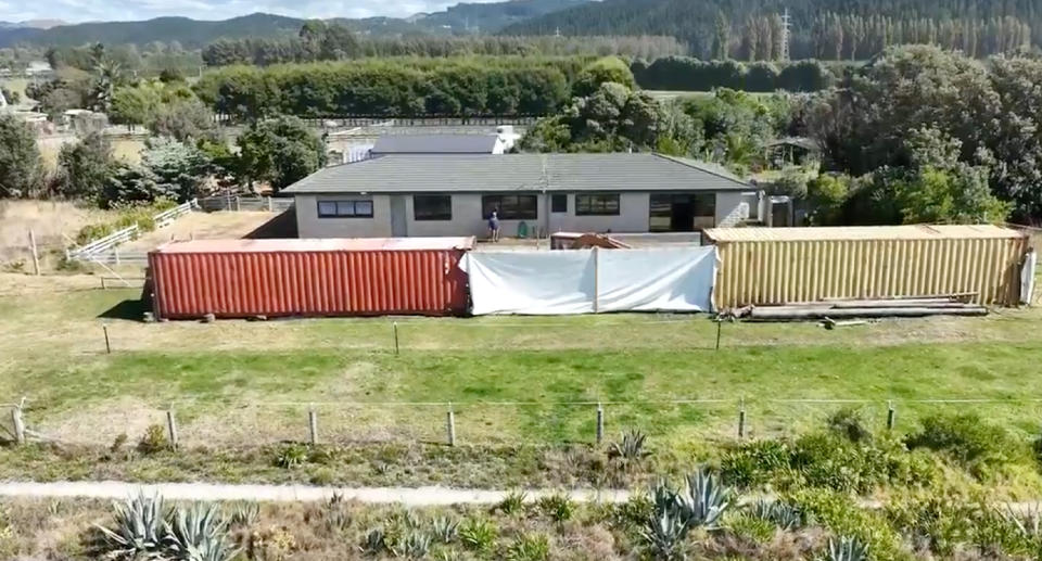 The two shipping containers and tarps in front of the Dewar's Napier home in New Zealand.