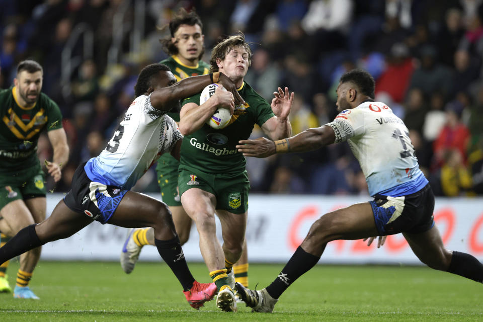 Pictured centre, Australia's Harry Grant breaks clear during a tackle against Fiji in their opening game at the Rugby League World Cup.