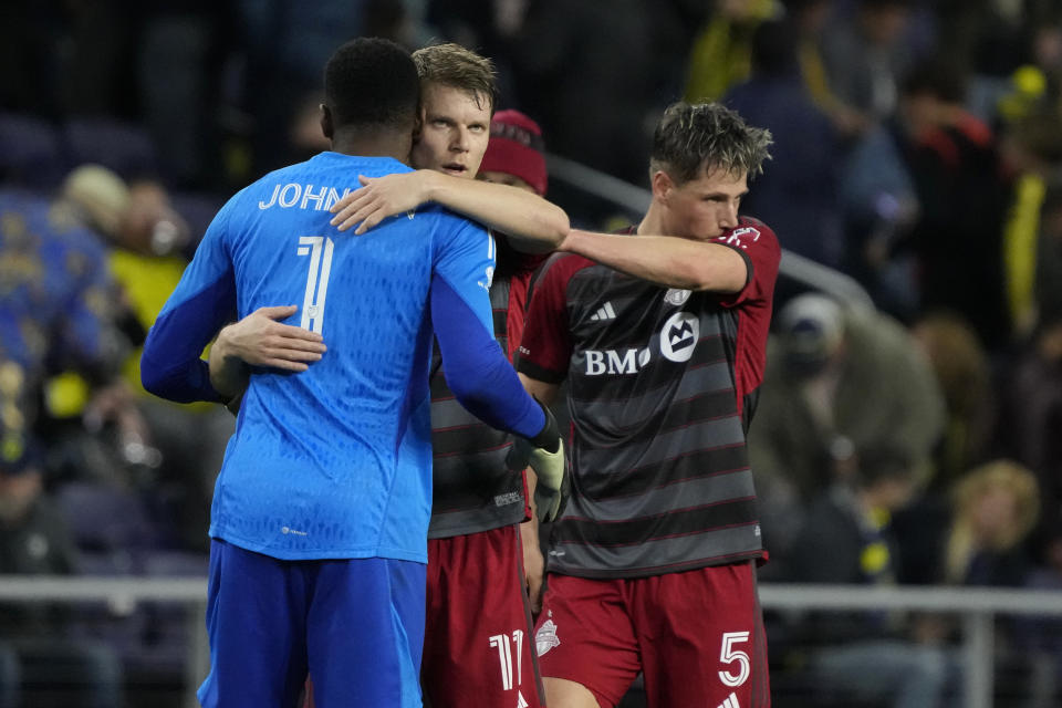 Toronto FC goalkeeper Sean Johnson (1) is hugged by defender Sigurd Rosted (17) after Toronto FC and Nashville SC played to a scoreless draw in an MLS soccer match Saturday, April 8, 2023, in Nashville, Tenn. (AP Photo/Mark Humphrey)