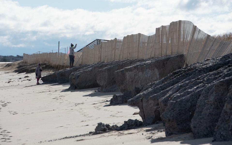 Andrew and Elizabeth Cattano survey damage on Wednesday to a newly reinforced protective dune at Town Neck Beach in Sandwich. Tuesday's fast-moving storm didn't linger over multiple tide cycles, which could have exacerbated erosion and flooding damage, a town official said.