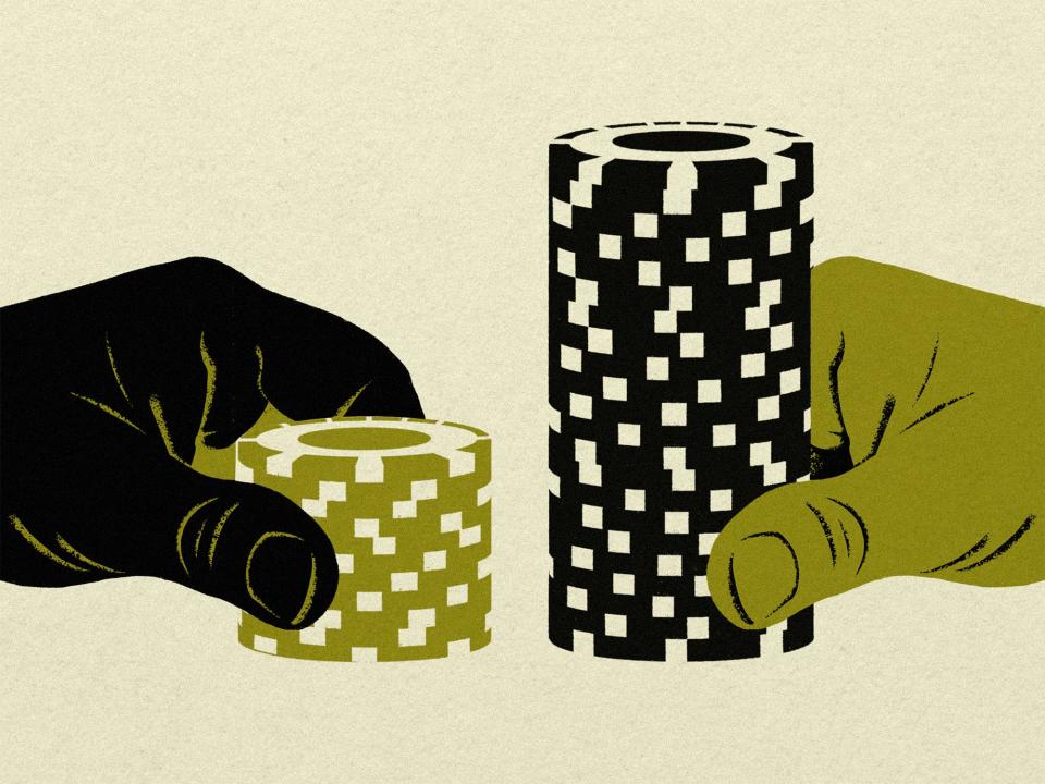 two hands coming in from the left and right pushing in a small stack of poker chips and a large stack of poker chips