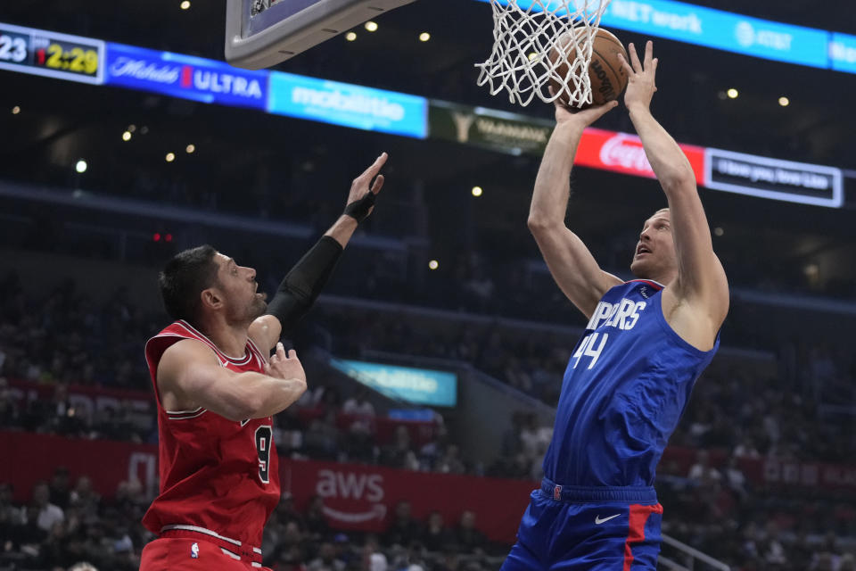 Los Angeles Clippers center Mason Plumlee (44) shoots over Chicago Bulls center Nikola Vucevic (9) during the first half of an NBA basketball game Monday, March 27, 2023, in Los Angeles. (AP Photo/Marcio Jose Sanchez)