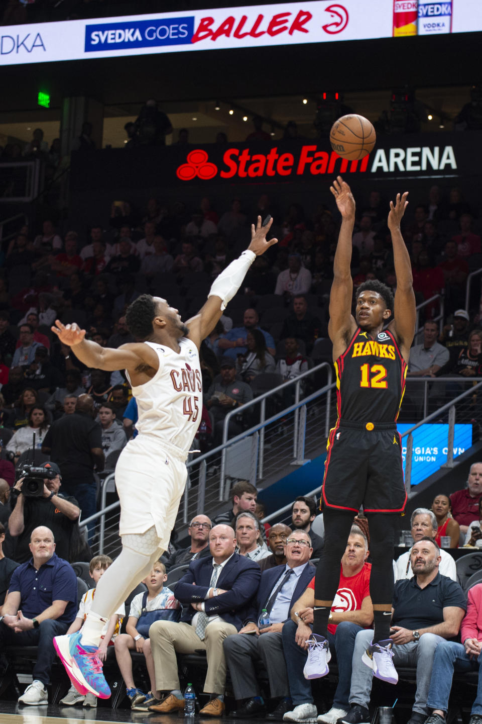 Atlanta Hawks forward De'Andre Hunter shoots a 3-pointer against Cleveland Cavaliers guard Donovan Mitchell during the first half of an NBA basketball game Tuesday, March 28, 2023, in Atlanta. (AP Photo/Hakim Wright Sr.)