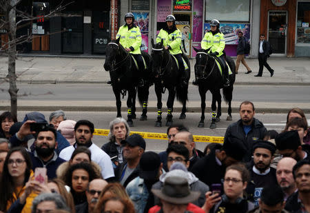 Mounted police stand by as mourners visit a makeshift memorial a day after a van struck multiple people along a major intersection in north Toronto, Ontario, Canada, April 24, 2018. REUTERS/Carlo Allegri