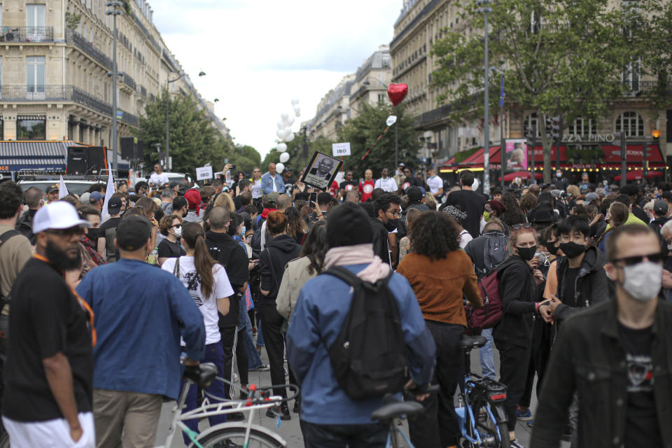 People gather during a protest in memory of Lamine Dieng, a 25-year-old Franco-Senegalese who died in a police van after being arrested in 2007, in Paris, Saturday, June 20, 2020. Multiple protests are taking place in France on Saturday against police brutality and racial injustice, amid weeks of global anger unleashed by George Floyd's death in the US. (AP Photo/Rafael Yaghobzadeh)