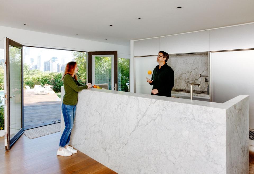 Although many kitchen redesigns aim for more openness, in John and Debby’s case, it made more sense to section off their sprawling kitchen into a smaller cooking area, a sizable butler’s pantry, and a snug TV room. The sculptural island and backsplash are made from Cararra marble.