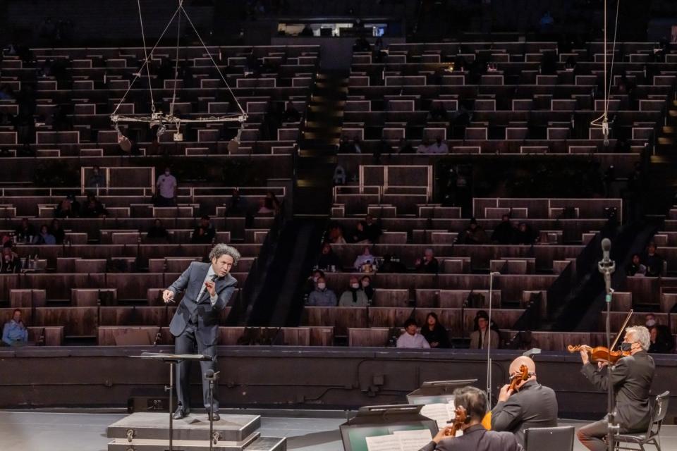 A view from stage as Gustavo Dudamel conducts the L.A. Phil, looking out toward an audience scattered in the Bowl's boxes.