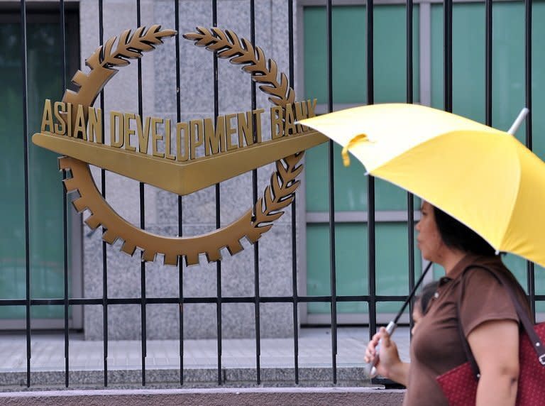 A pedestrian passes in front of the headquarters of the Asian Development Bank in Manila. Asia's decades-long march to prosperity, a new study has said, is being led by seven economies with more than three billion people between them -- China, India, Indonesia, Japan, South Korea, Thailand and Malaysia