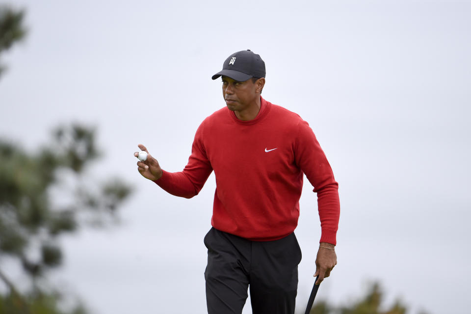 Tiger Woods holds up the ball after putting the fourth hole of the South Course at Torrey Pines Golf Course during the final round of the Farmers Insurance golf tournament Sunday, Jan. 26, 2020, in San Diego. (AP Photo/Denis Poroy)