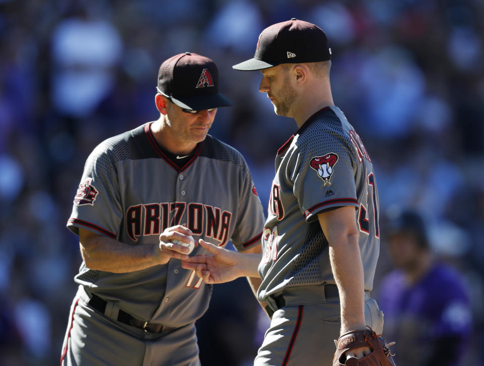 Arizona Diamondbacks manager Torey Lovullo, left, takes the ball from relief pitcher Brad Boxberger who is pulled from the mound after getting Colorado Rockies' Chris Iannetta to fly out in the seventh inning of a baseball game Thursday, Sept. 13, 2018, in Denver. (AP Photo/David Zalubowski)