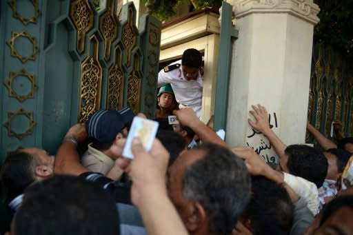 Egyptian guards try to close the gate of presidential palace to the people wanting to make personal requests to President Mohamed Morsi in Cairo. The ruling military convened an urgent meeting "to discuss the presidential measures" state television says