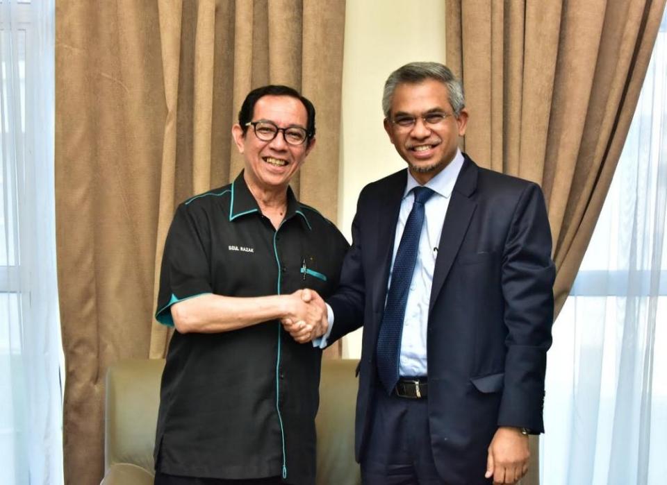 IIUM rector Prof Emeritus Tan Sri Dzulkifli Abdul Razak shakes hands with the university's new president Datuk Mohd Daud Bakar (right). — Picture courtesy of IIUM