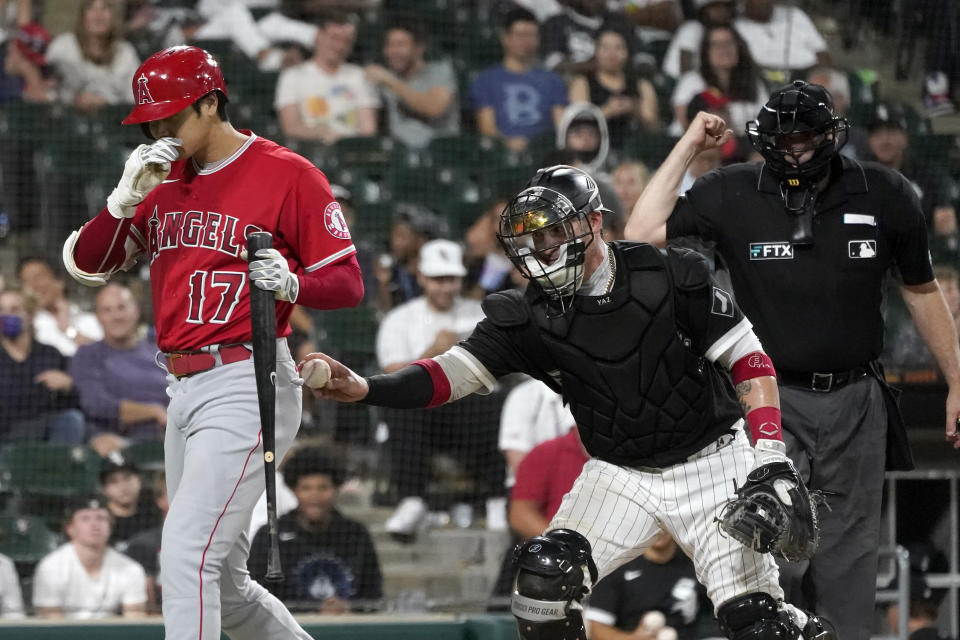 Chicago White Sox catcher Yasmani Grandal, center, tags out Los Angeles Angels' Shohei Ohtani after a dropped third strike, as home plate umpire Bill Welke makes the call during the ninth inning of a baseball game Tuesday, Sept. 14, 2021, in Chicago. The White Sox won 9-3. (AP Photo/Charles Rex Arbogast)