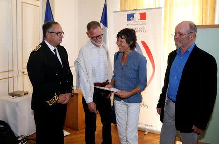 Amanda Holmes, aged 67 and her husband Robin Holmes (R), aged 71, hold a French naturalization decree during a citizenship ceremony at the Sub-Prefecture in Niort, France, October 9, 2018. REUTERS/Stephane Mahe