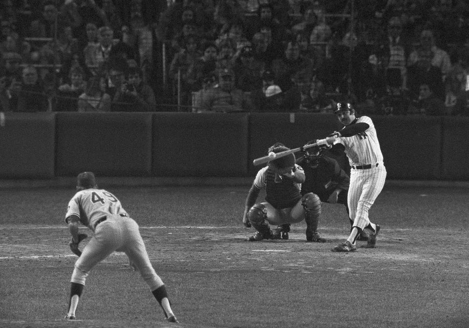 New York Yankees Thurman Munson connects with the ball for a double in the seventh inning of the World Series game with the Los Angeles Dodgers in New York, Oct. 15, 1978. Munson knocked in two runs with the hit . Yanks won,12-2, with Munson getting three hits and knocking in five runs. Dodger catcher Johnny Oates and umpire is Frank Pulli also seen in the photo.