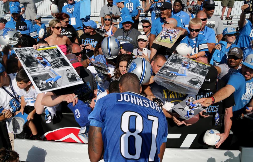 Detroit Lions wide receiver Calvin Johnson signs autographs after the first day of training camp on Monday, Aug. 3, 2015, at the Allen Park practice facility in Allen Park, Mich.
