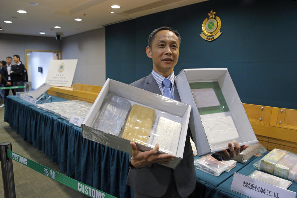 Head of Customs Drug Investigation Bureau Hui Wai-ming holds the seized cocaine during a news conference in Hong Kong, Thursday, April 4, 2019. A haul of cocaine with an estimated market value of $13 million has been seized in Hong Kong, customs agents said Thursday.(AP Photo/Kin Cheung)