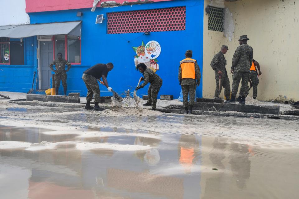 Staff from the Barbados Defence Force clear sand from the south coast's main road after the passage of Hurricane Beryl in Christ Church, Barbados, on July 1, 2024.