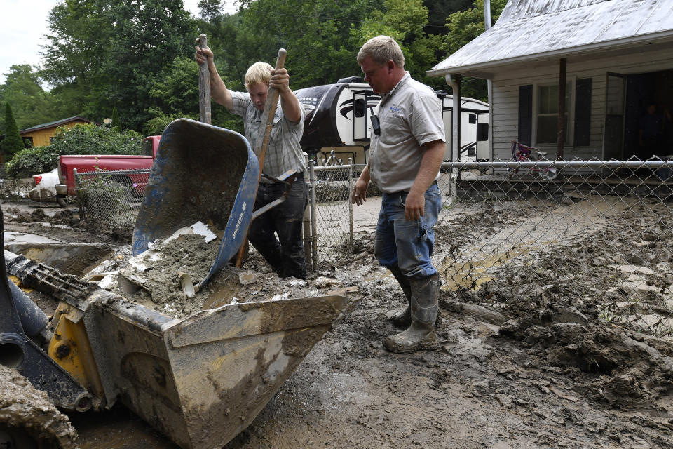 Volunteers from the local Mennonite community clean flood damaged property from a house at Ogden Hollar in Hindman, Ky., Saturday, July 30, 2022. (AP Photo/Timothy D. Easley)