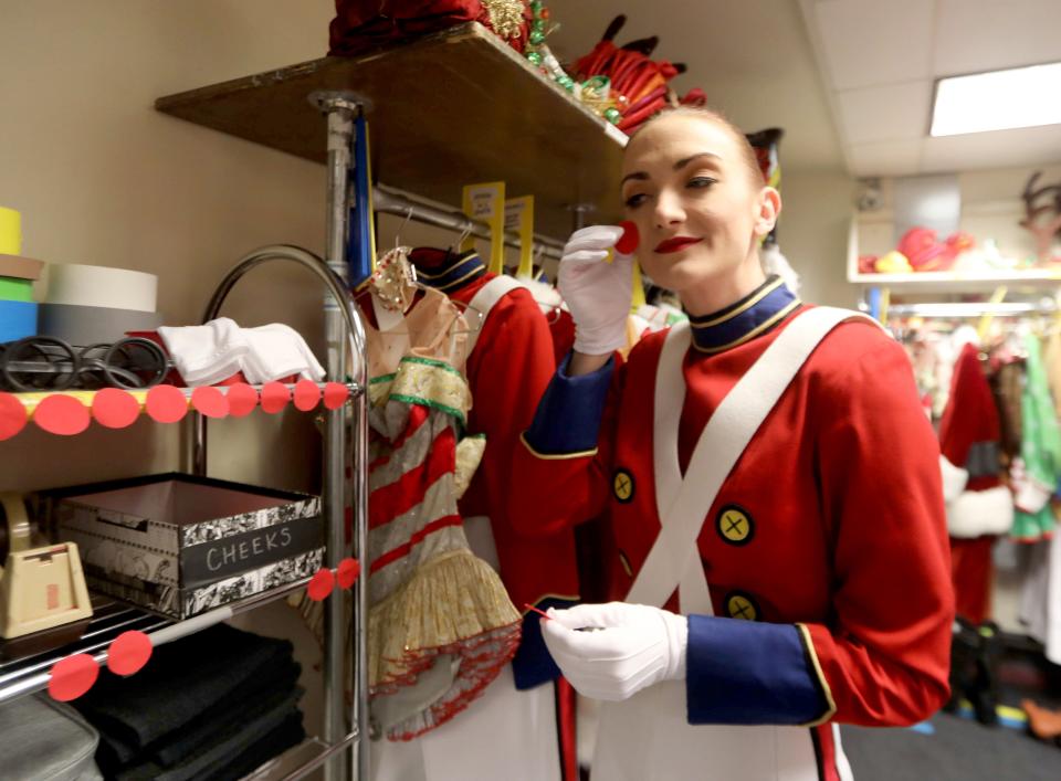 Radio City Rockette Bailey Callahan places a red sticker on her cheek as she dresses for the "Parade of the Wooden Soldiers" musical number of the Radio City Christmas Spectacular Nov. 30, 2021.