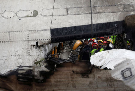 Rescue workers work at the wreckage of a US-Bangla airplane after it crashed at the Tribhuvan International Airport in Kathmandu, Nepal March 12, 2018. REUTERS/ Navesh Chitrakar