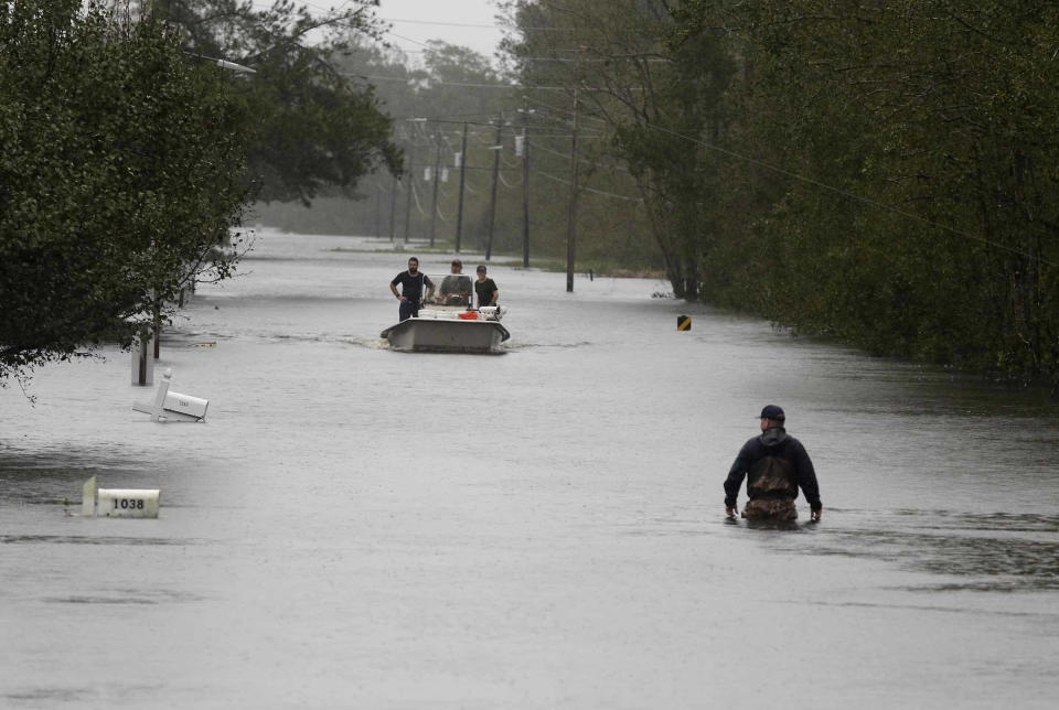 Un miembro de la Guardia Costera camina entre las aguas de una inundación causada por el huracán Florence en Newport, Carolina del Norte, el sábado 15 de septiembre de 2018. (AP Foto/Tom Copeland)